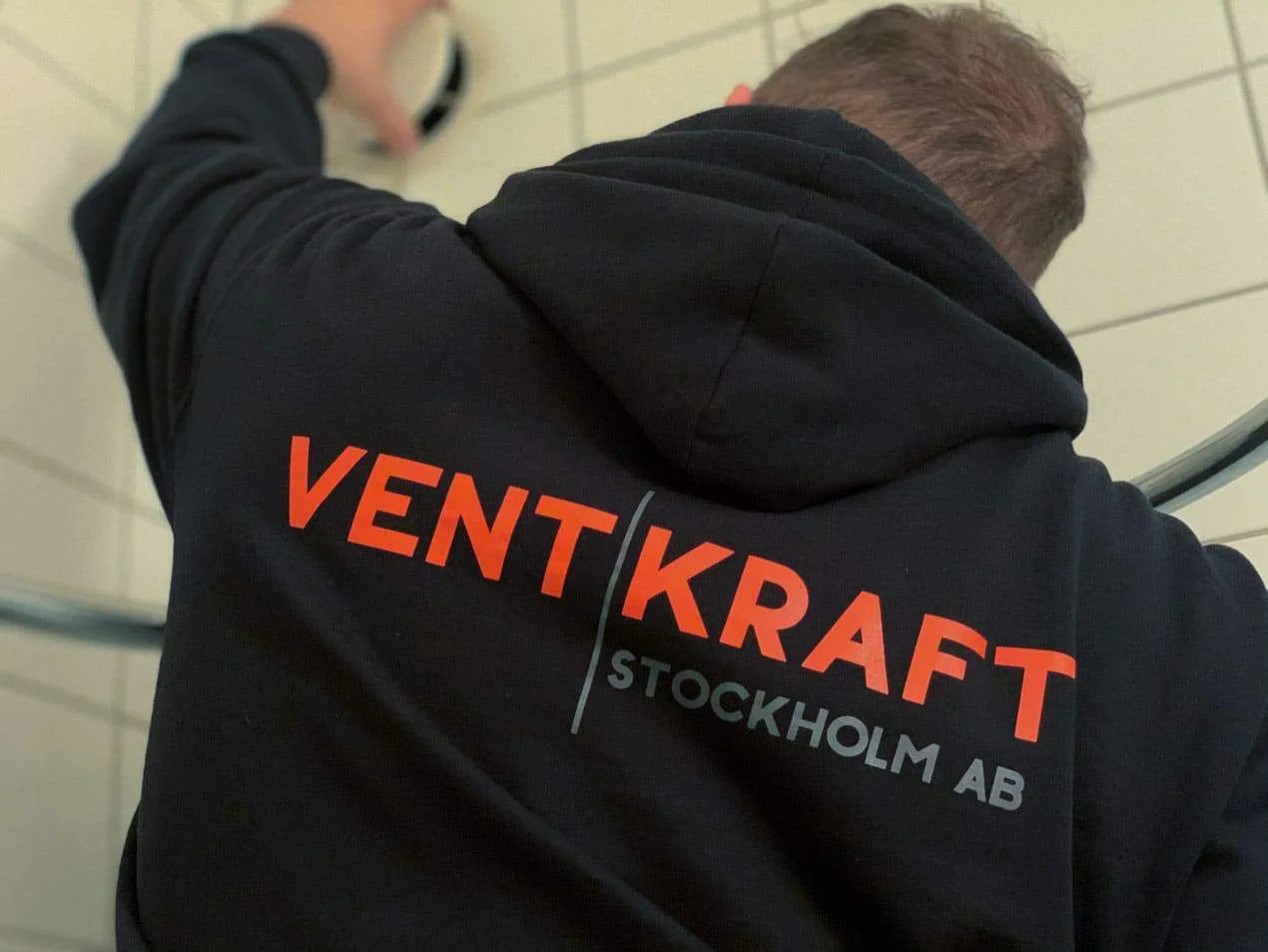 Ventkraft-tekniker monterar ett ventilationsdon i ett badrum